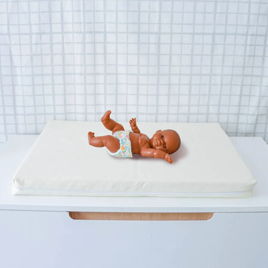L’alèse sur le matelas à langer écru, posée sur le plan de change.