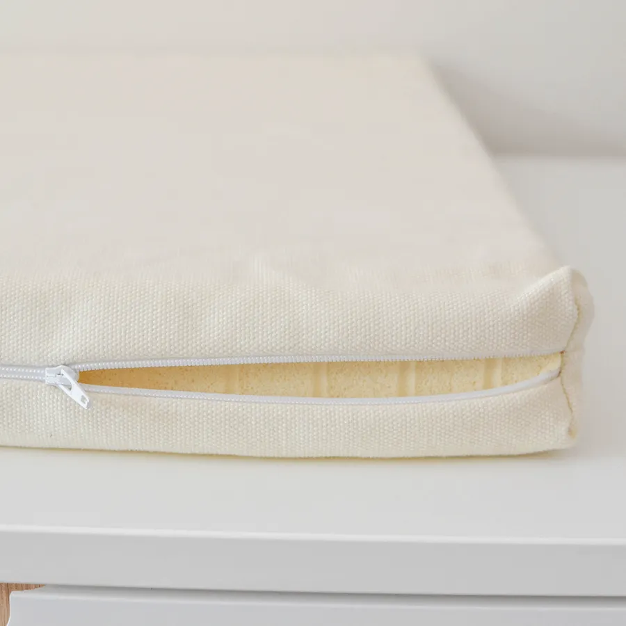 L’alèse zippée en gros plan, la mousse en latex visible à l’intérieur.