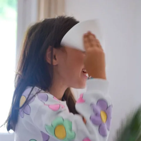 Petite fille qui s'essuie le visage avec une lingette lavable blanche