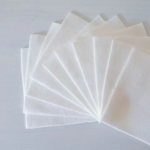 Dix lingettes lavables en coton blanc disposées en éventail