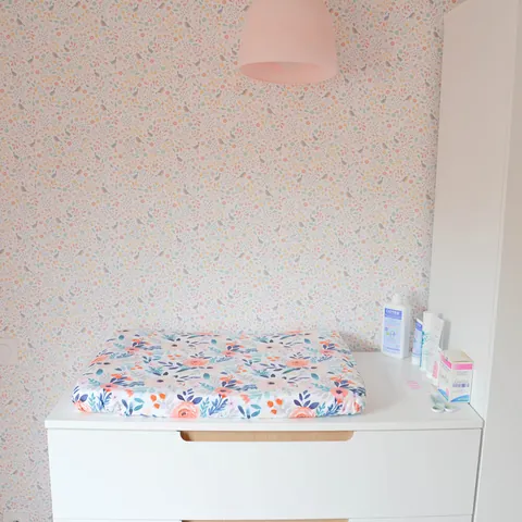 Coin change complet : matelas à langer Bouquet sur la commode, papier peint fleuri et suspension rose