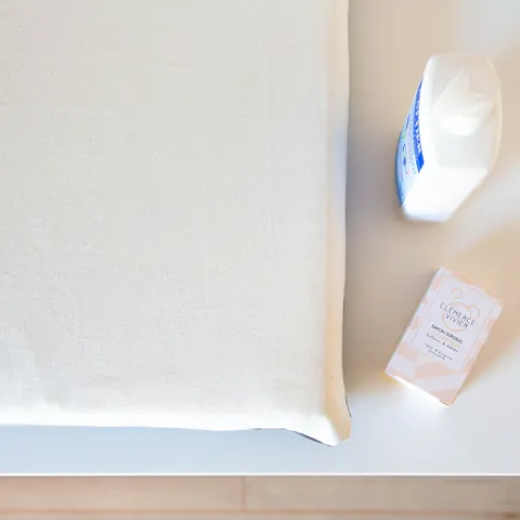 Matelas à langer écru uni vu de dessus, flacon et savon