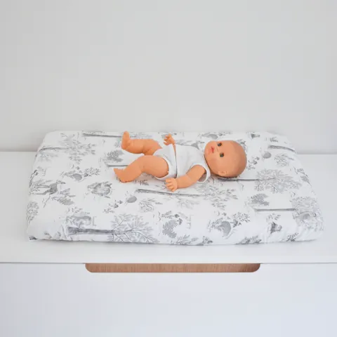 Poupon sur le matelas à langer Doux sous-bois, vue de face sans logo