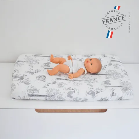 Poupon sur le matelas à langer Doux sous-bois gris et blanc, logo Origine France Garantie