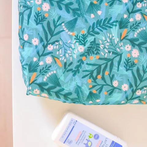 Angle du matelas à langer Forêt magique vu de dessus, flacon de lait de toilette