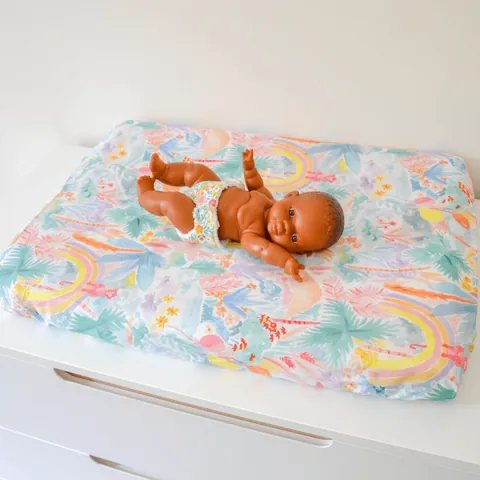 Poupon sur le matelas à langer Jungle pastel vu de biais