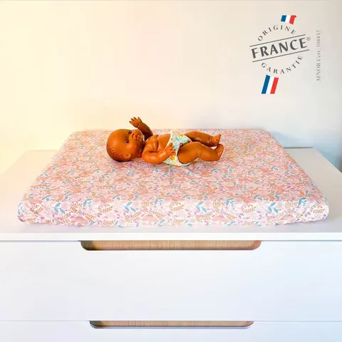 Poupon sur le matelas à langer Poésie rose à petites fleurs, logo Origine France Garantie