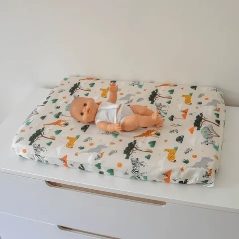 Poupon sur le matelas à langer Savane vu de biais
