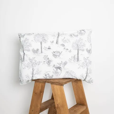 Oreiller housse doux sous-bois posé sur un tabouret en bois, fond blanc