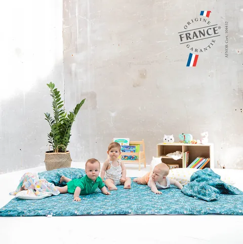 Trois bébés sur la surhousse géante bleu canard à feuillages, plante et bibliothèque, logo Origine France Garantie