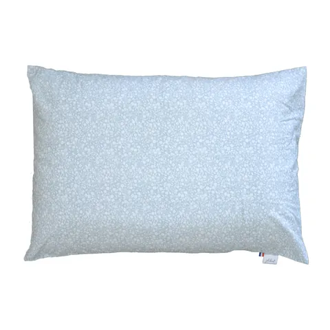 Oreiller housse vert de gris à petites fleurs blanches, posé à plat sur fond blanc
