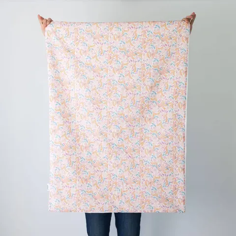 Couverture poésie dépliée, tenue à bout de bras devant un mur blanc