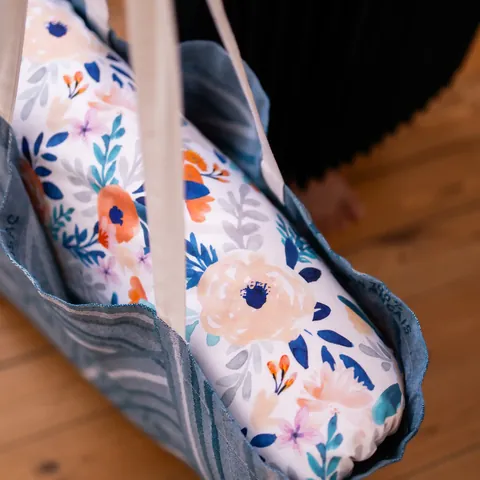 Tapis Bouquet printanier plié dans le sac cabas bleu tissé, gros plan