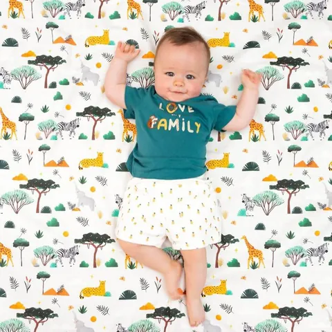 Bébé bras levés, allongé sur le Tapis Magique Dans ma savane
