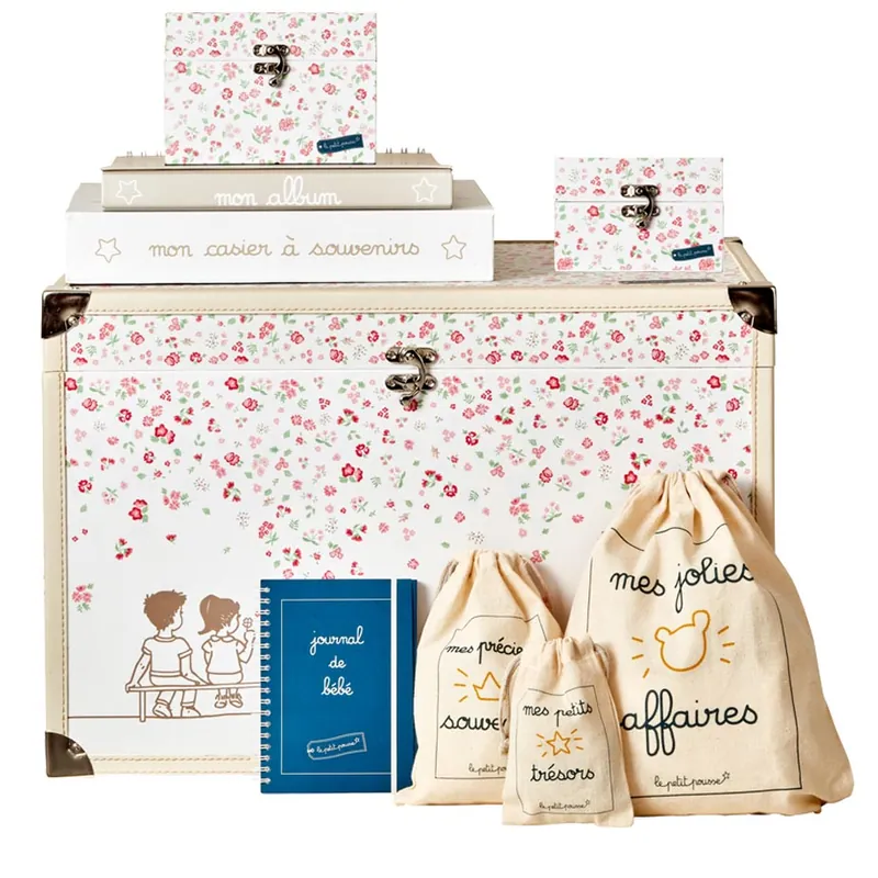 Une malle à souvenirs imprimée de petites fleurs roses, avec album, coffrets, journal de bébé et pochons en coton « mes jolies affaires »
