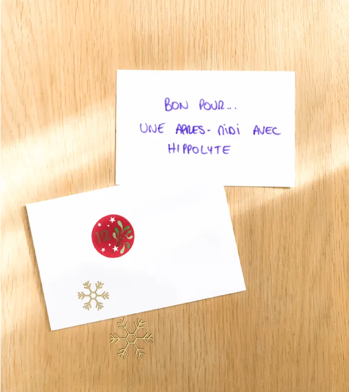 Un carton écrit à la main « Bon pour... une après-midi avec Hippolyte », au-dessus d'une enveloppe marquée d'une gommette rouge