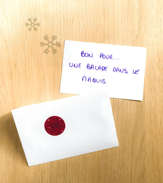 Un carton écrit à la main « Bon pour... une balade dans le maquis », à côté d'une enveloppe marquée d'une gommette rouge
