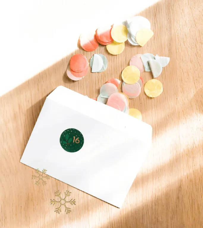 Des confettis pastel qui s'échappent d'une enveloppe blanche marquée d'une gommette 16