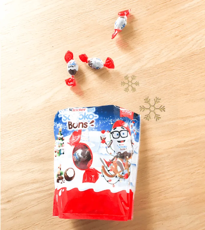 Un sachet de Schokobons et quelques bonbons emballés sur une table en bois
