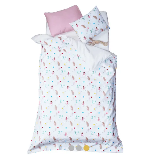 Une parure de lit enfant blanche imprimée de petites danseuses et de pois de couleur, avec un coussin rose