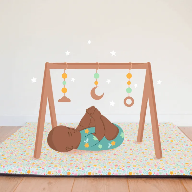 Illustration d'un bébé allongé sur le dos, qui attrape ses pieds sous une arche d'éveil en bois, sur un tapis fleuri